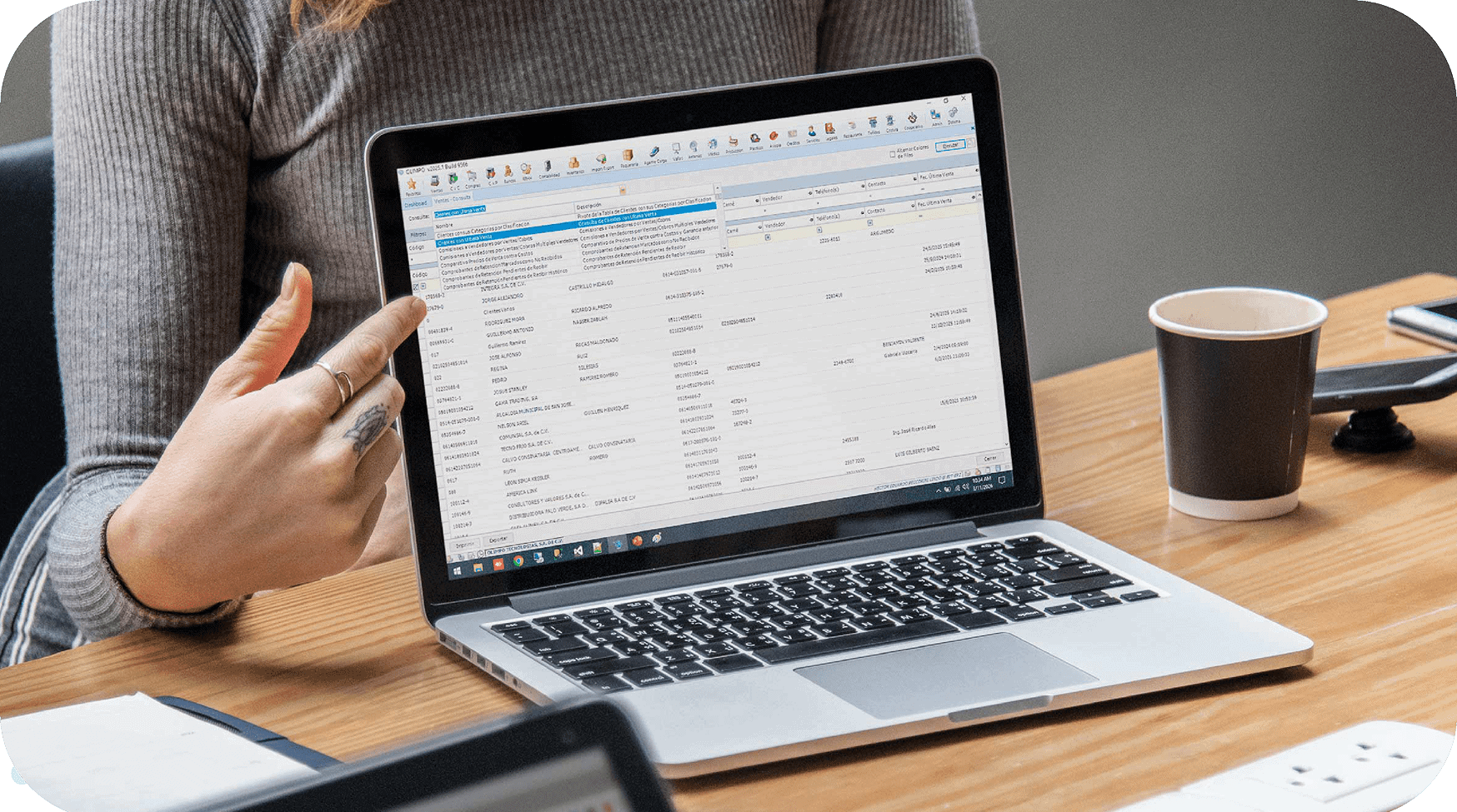 Persona señalando la pantalla de una computadora portátil con un módulo del ERP Olimpo